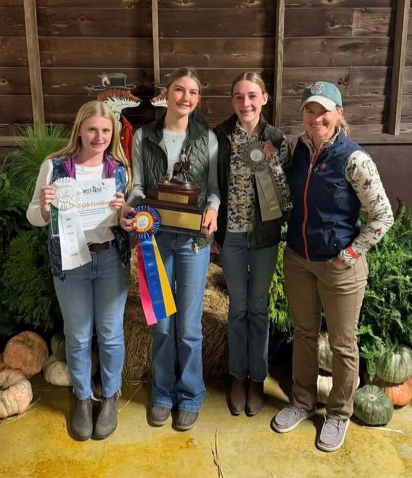 Three girls and woman holding ribbons and trophis